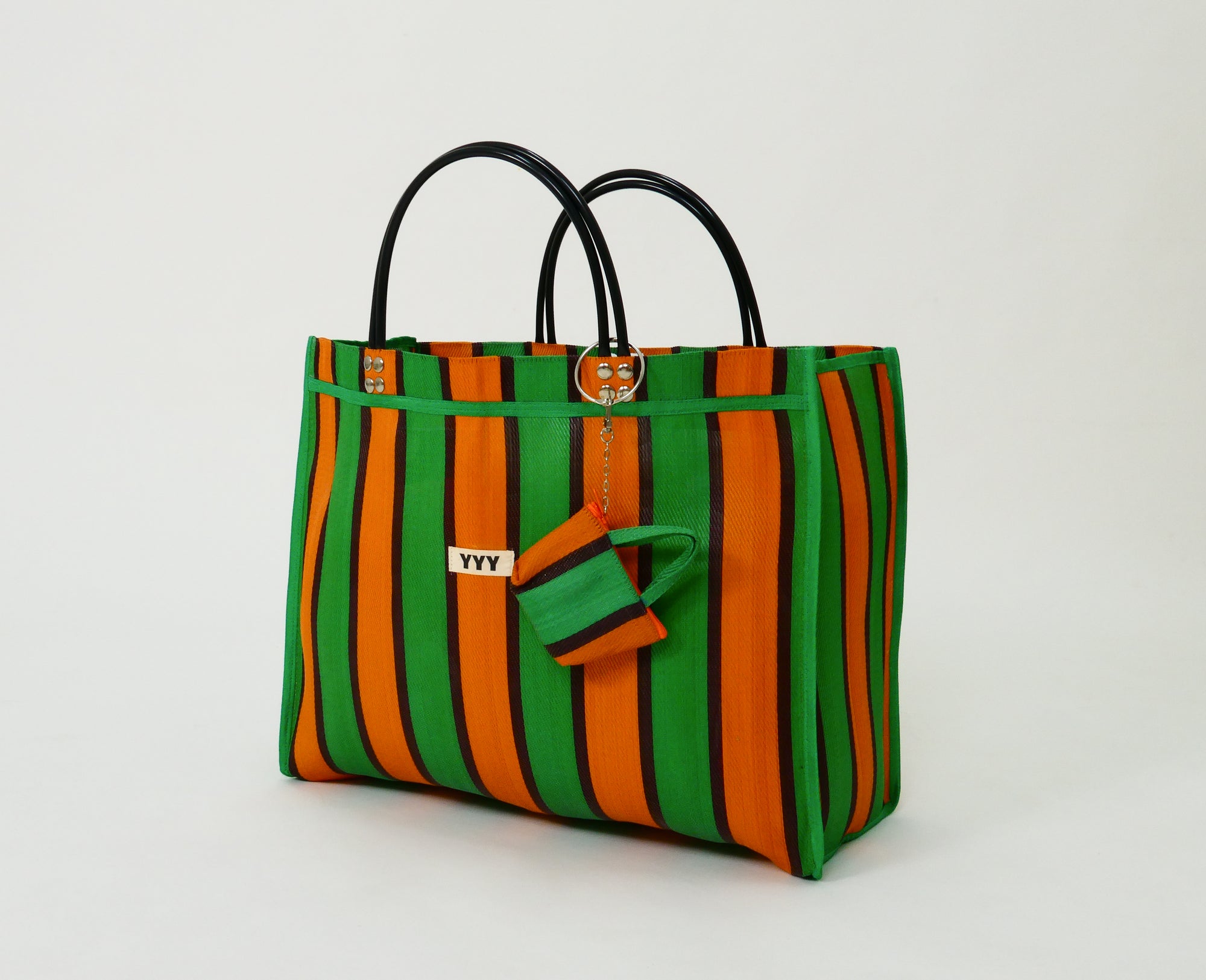 Side view of The Huge orange and green striped tote bag with matching mini pouch