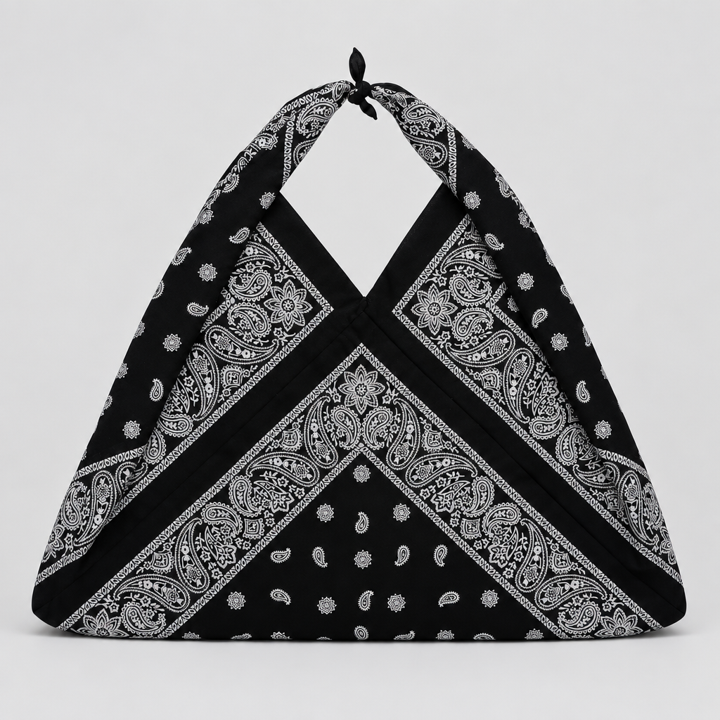 A black halter-style shoulder bag made from a paisley bandana, featuring a tied top knot and a draped triangular shape,