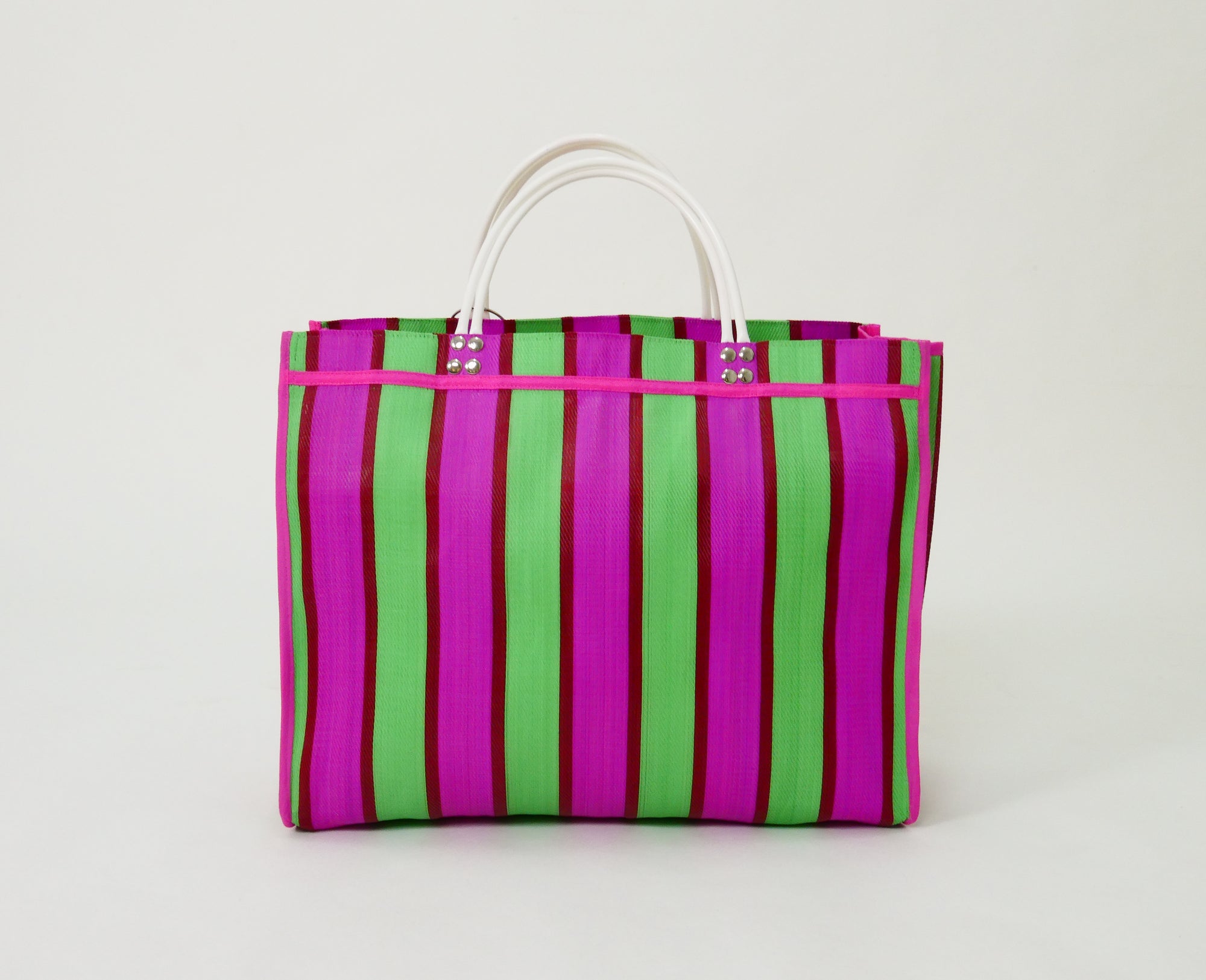 The Huge handmade tote bag made from recycled plastic in pink, green, and white handels 