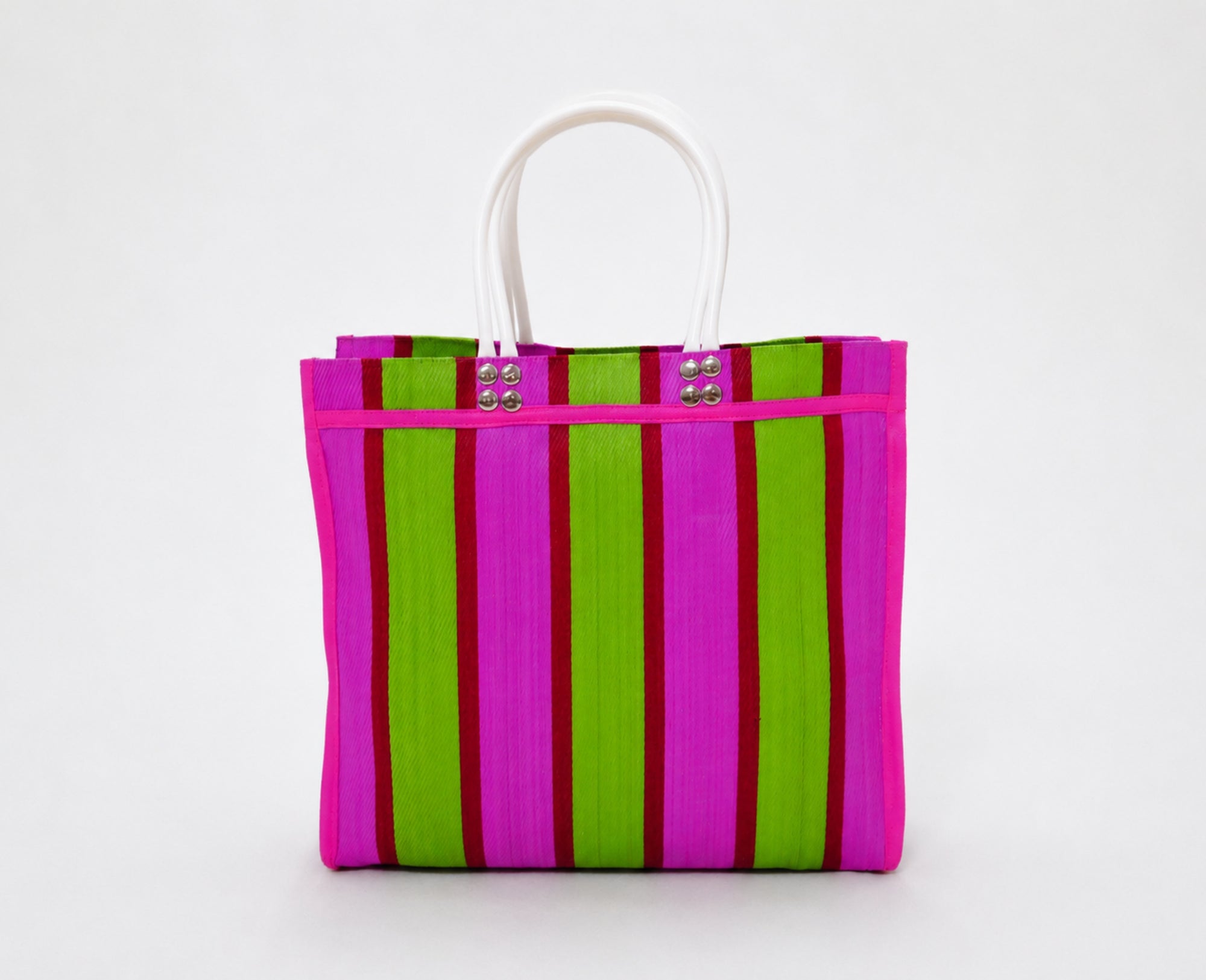 The Tote is a handmade everyday bag featuring bright pink and green stripes. Crafted from 100% recycled plastic, it combines durability, functionality, and expressive design.